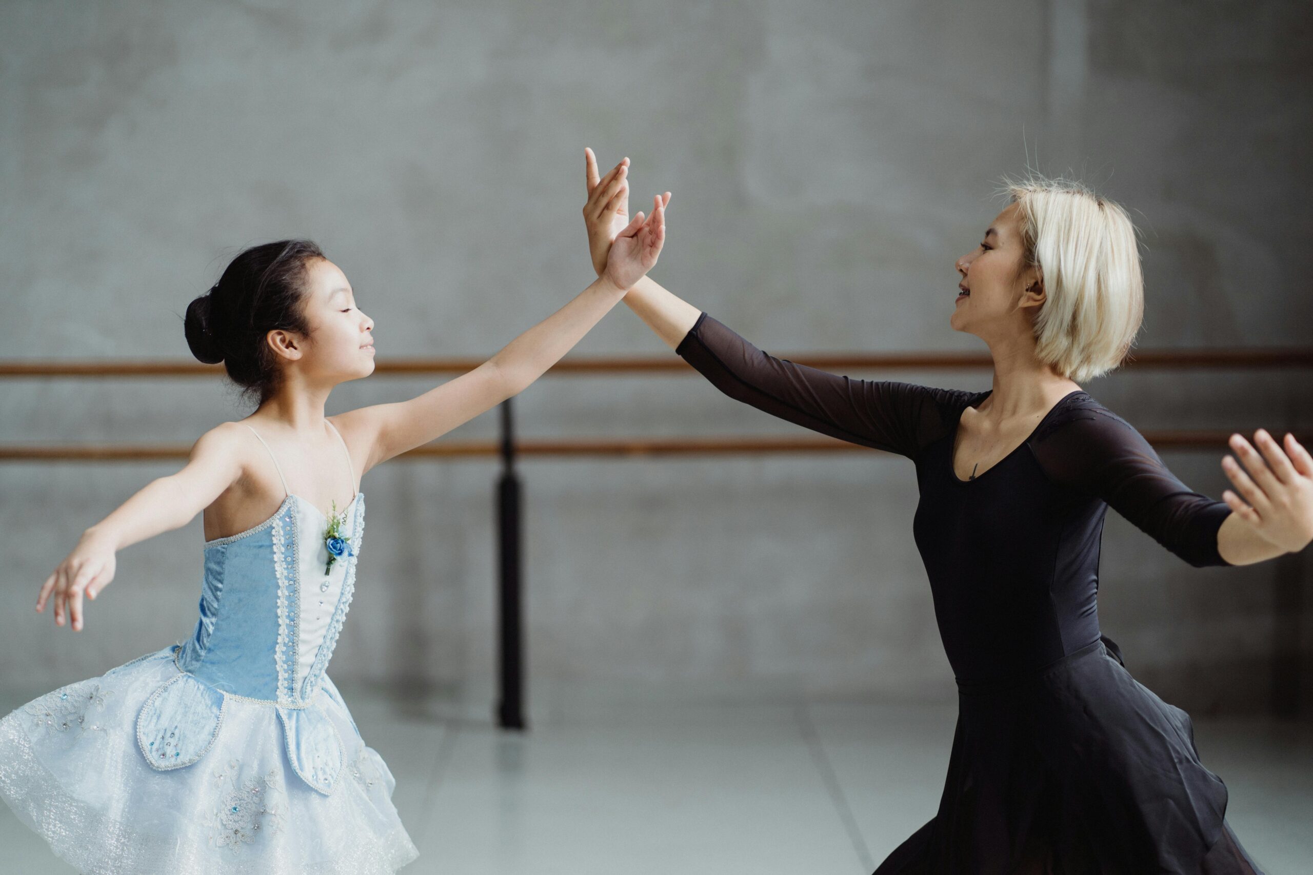 Ballet teacher practicing techniques with a young ballet student